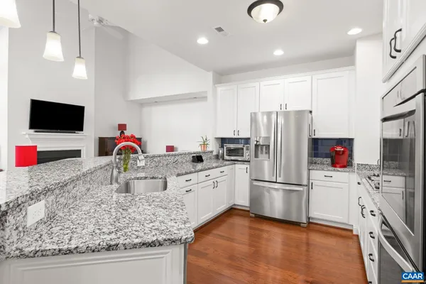 a kitchen with stainless steel appliances granite countertop a refrigerator and a sink