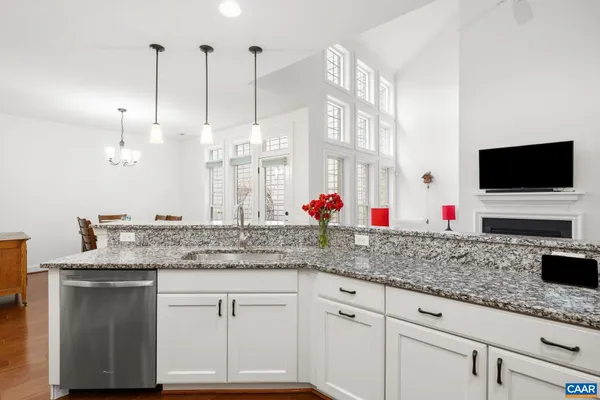 a kitchen with granite countertop a sink and white cabinets