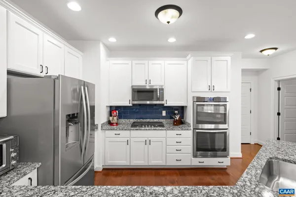 a kitchen with stainless steel appliances a refrigerator sink and cabinets