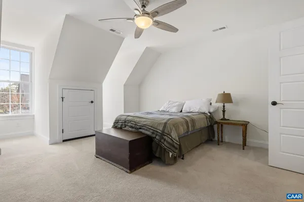 a spacious bedroom with a bed and a chandelier