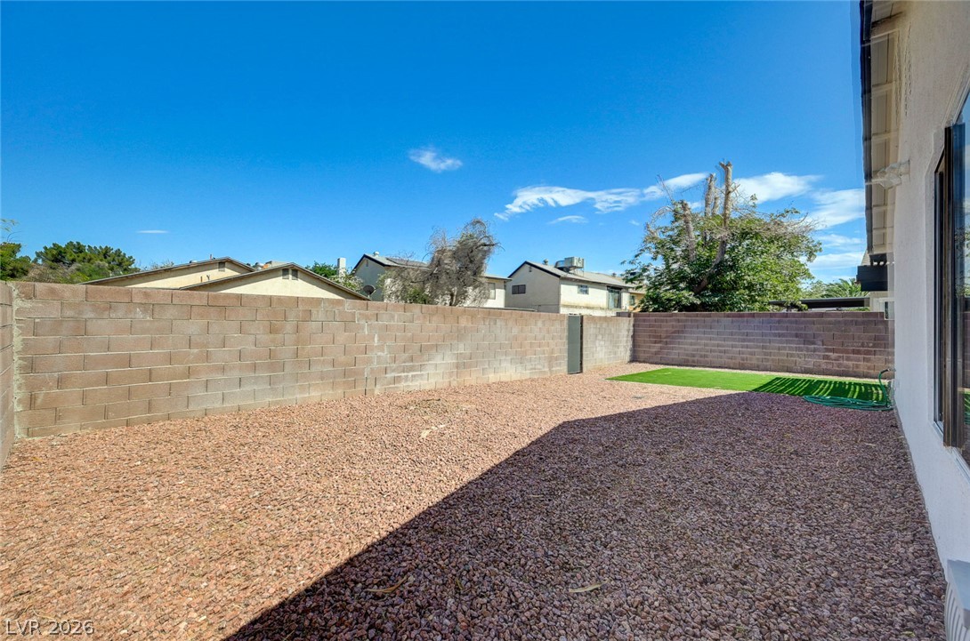 4840 Summerhill Road Las Vegas, NV 89121 - Photo 44 of 56 A spacious backyard with a durable block fence offers a blend of gravel and a small patch of artificial turf.
