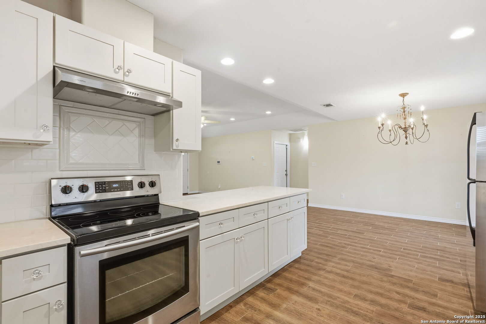 533 Indian Jourdanton, TX 78026 - Photo 11 of 27 a kitchen with a stove cabinets and wooden floor