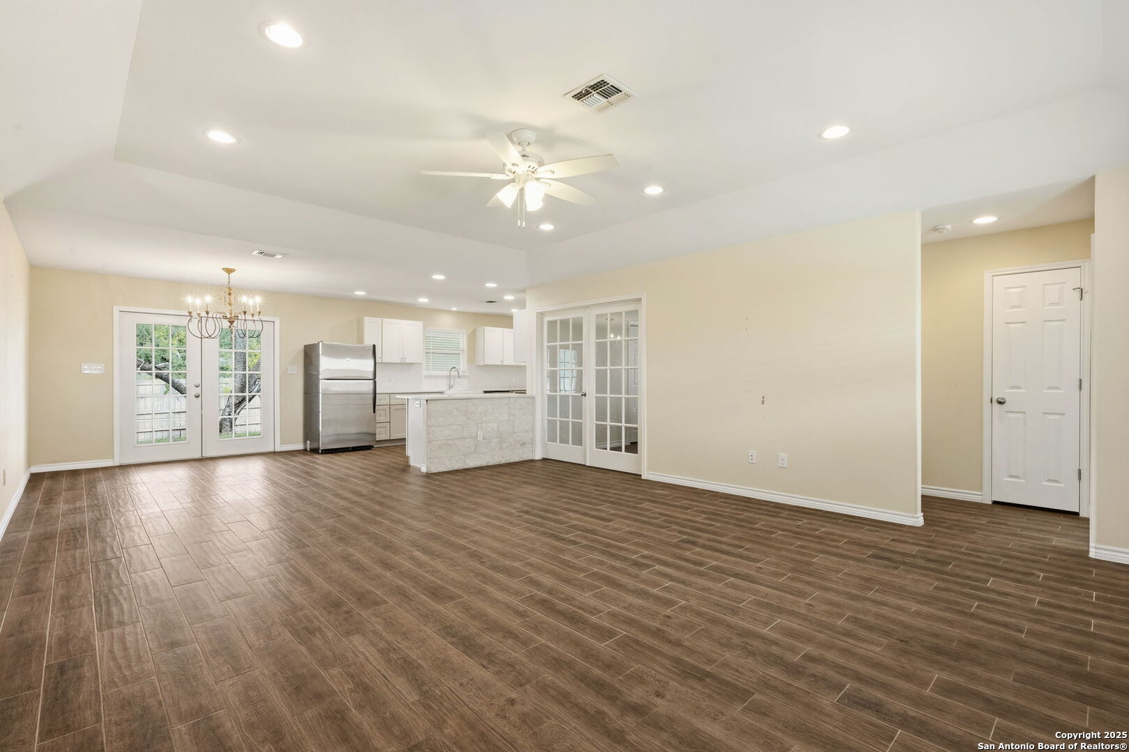 533 Indian Jourdanton, TX 78026 - Photo 3 of 27 a view of an empty room with wooden floor and a kitchen