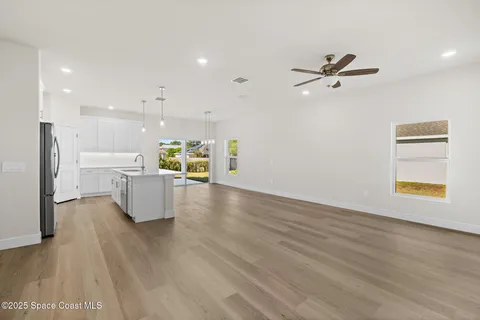 a kitchen with a sink dishwasher and a stove with wooden floor