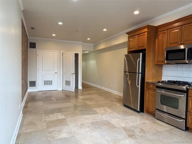 a view of a kitchen with a refrigerator and a stove top oven
