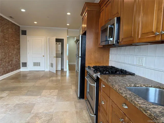 a kitchen with stainless steel appliances granite countertop a stove a refrigerator and a cabinets
