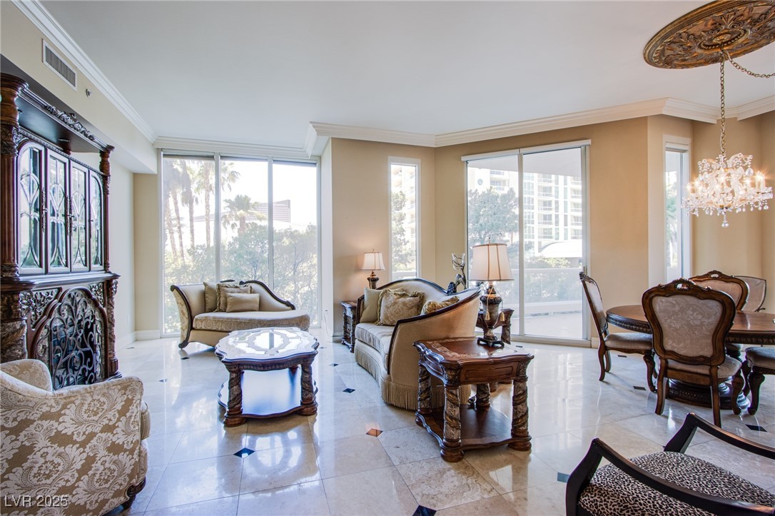 2857 Paradise Road, Unit 206 Las Vegas, NV 89109 - Photo 11 of 31 Living area featuring crown molding, plenty of natural light, a chandelier, and floor to ceiling windows