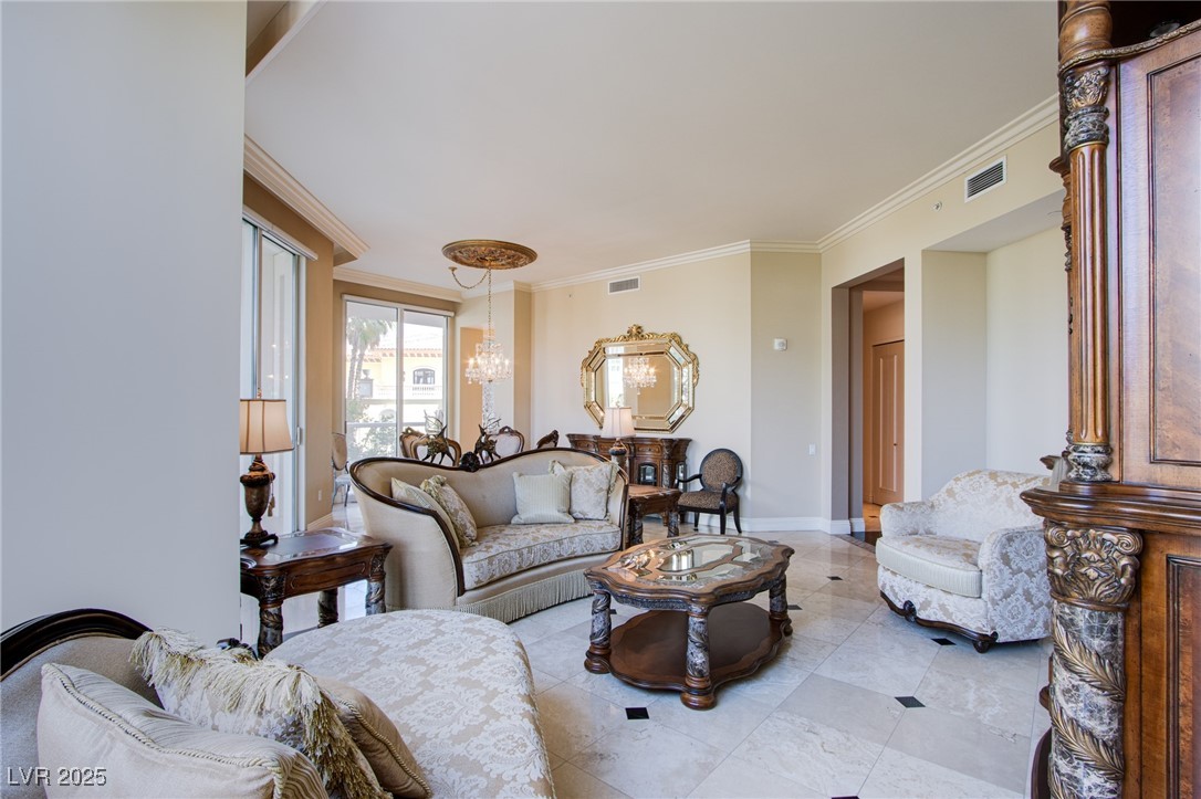 2857 Paradise Road, Unit 206 Las Vegas, NV 89109 - Photo 12 of 31 Living room with ornamental molding, a chandelier, and tile patterned flooring