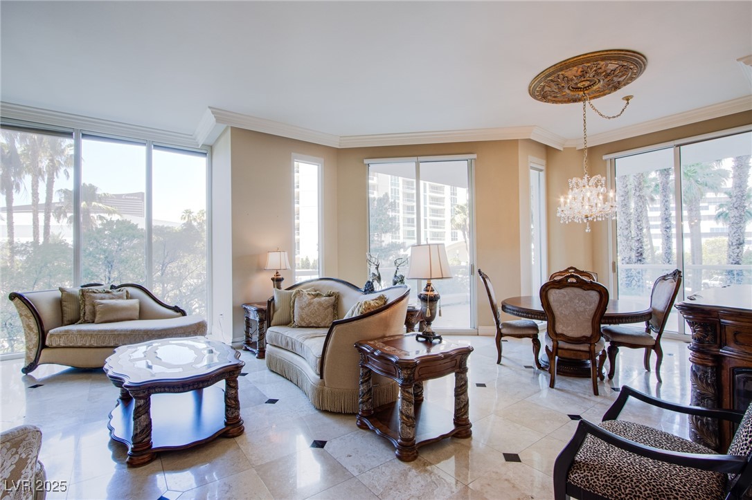 2857 Paradise Road, Unit 206 Las Vegas, NV 89109 - Photo 13 of 31 Living area with crown molding and a chandelier