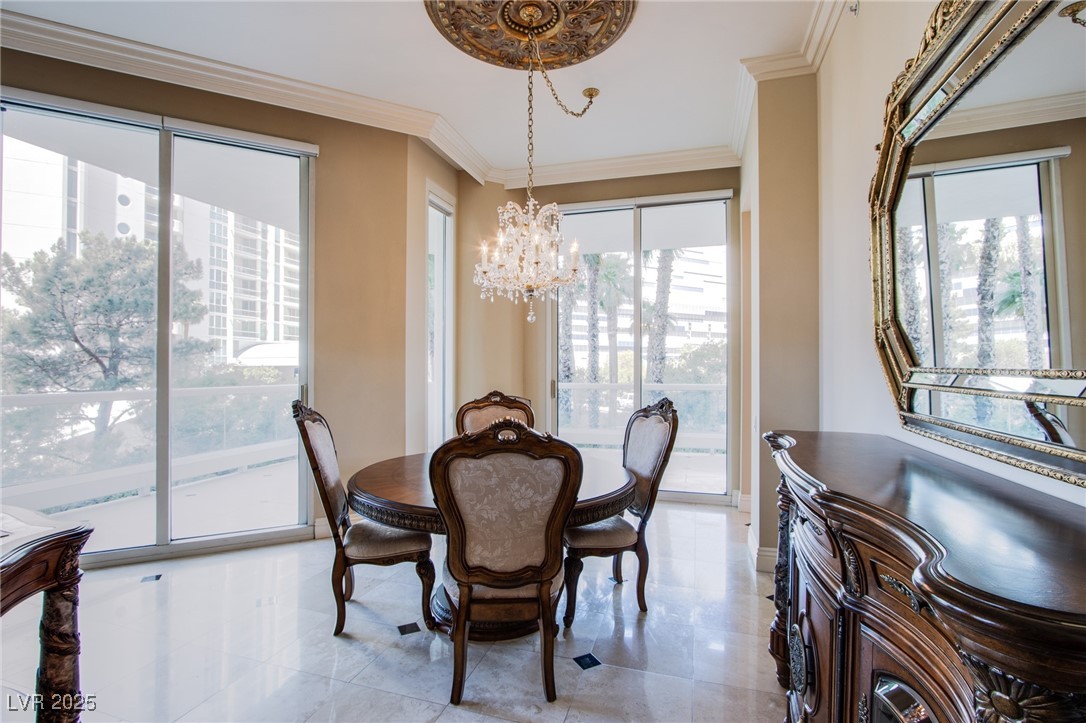2857 Paradise Road, Unit 206 Las Vegas, NV 89109 - Photo 15 of 31 Dining room with ornamental molding, a chandelier, and light tile patterned floors