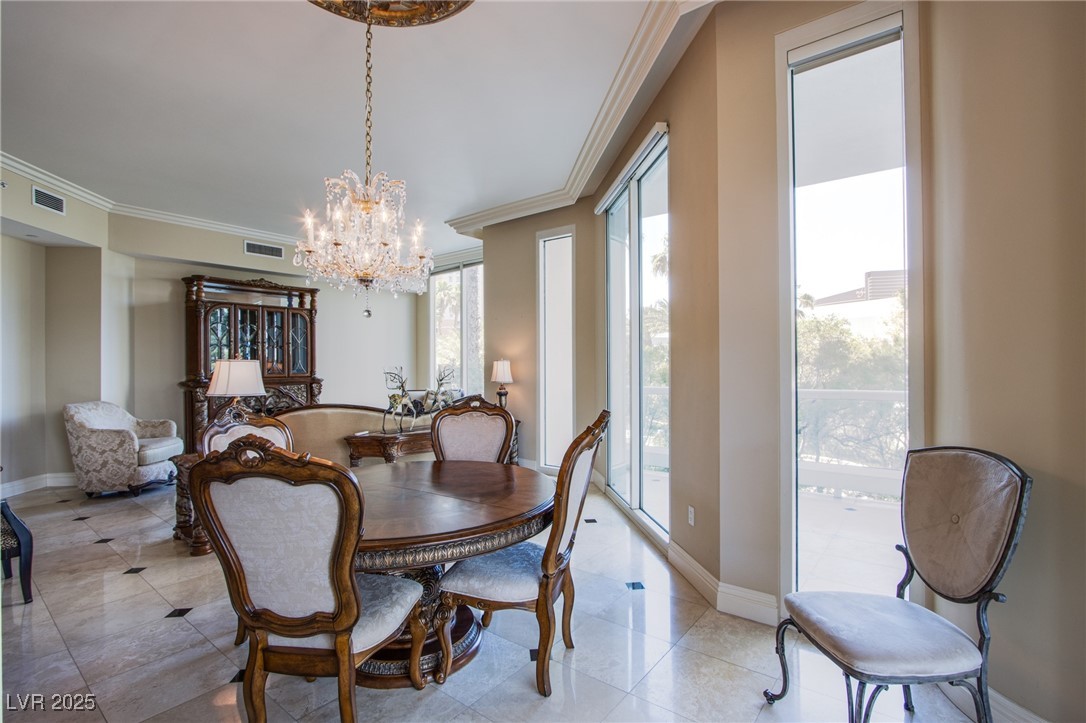 2857 Paradise Road, Unit 206 Las Vegas, NV 89109 - Photo 16 of 31 Dining room with ornamental molding, a chandelier, and light tile patterned flooring