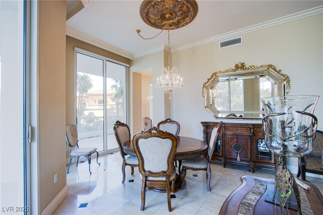 2857 Paradise Road, Unit 206 Las Vegas, NV 89109 - Photo 17 of 31 Dining area featuring ornamental molding, a chandelier, and tile patterned floors