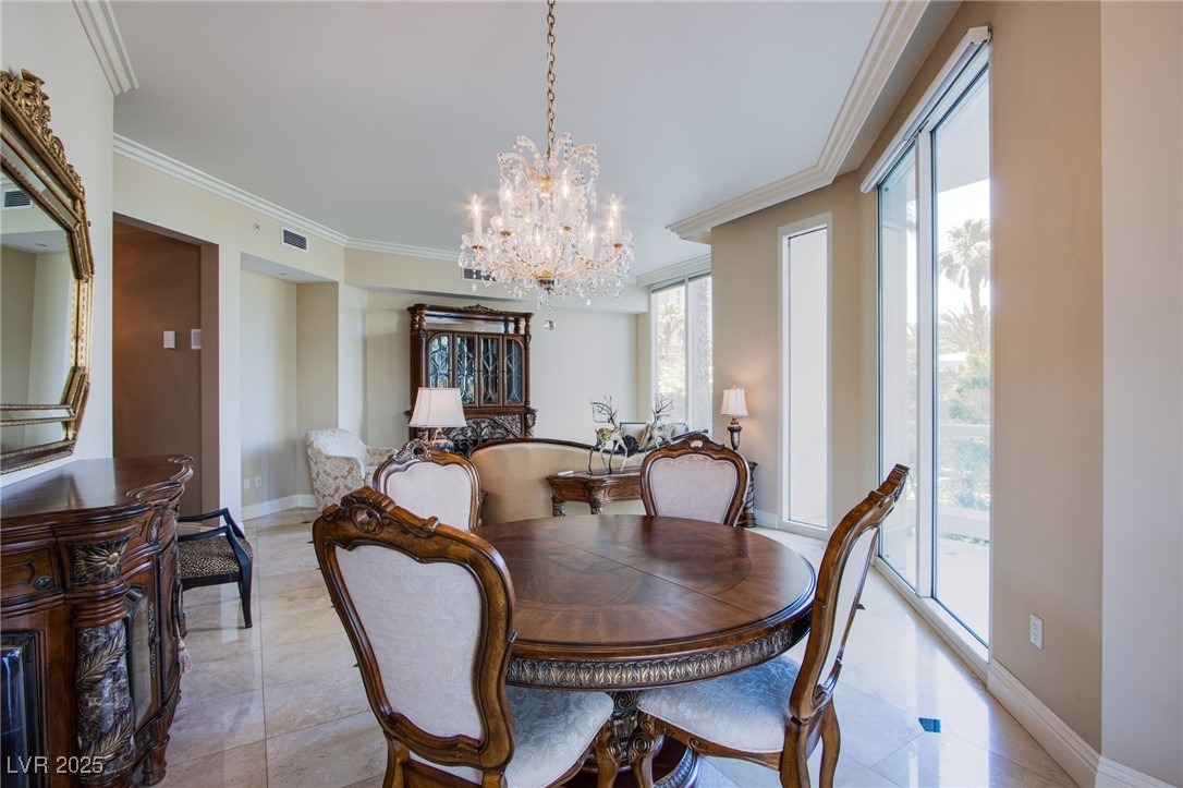 2857 Paradise Road, Unit 206 Las Vegas, NV 89109 - Photo 18 of 31 Dining room featuring crown molding, a chandelier, and light tile patterned floors