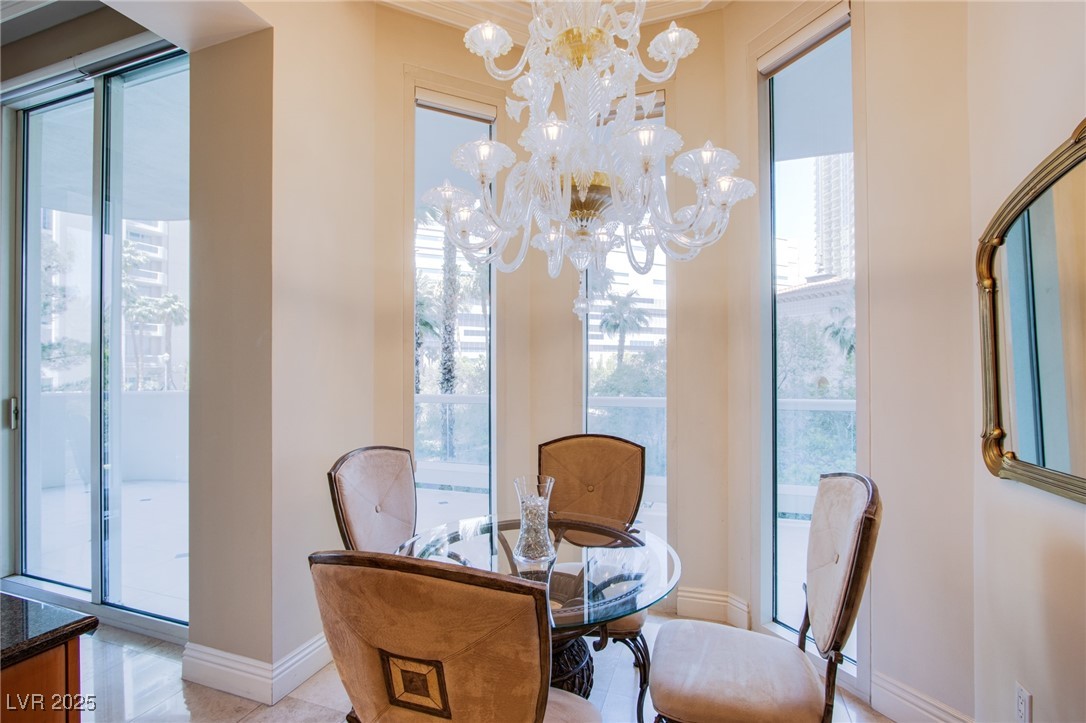 2857 Paradise Road, Unit 206 Las Vegas, NV 89109 - Photo 20 of 31 Tiled dining space featuring baseboards and a chandelier