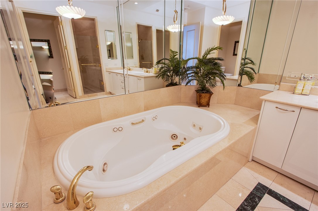 2857 Paradise Road, Unit 206 Las Vegas, NV 89109 - Photo 24 of 31 Full bathroom featuring a tub with jets, light tile patterned flooring, vanity, and a stall shower