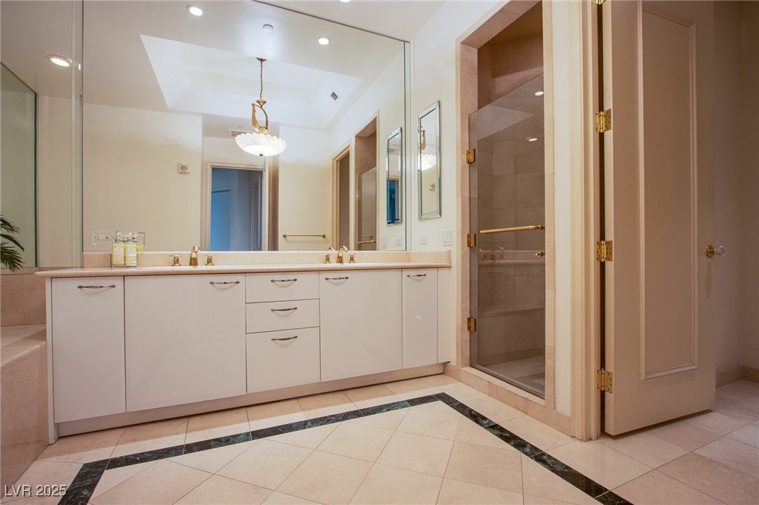 2857 Paradise Road, Unit 206 Las Vegas, NV 89109 - Photo 25 of 31 Full bathroom with inlaid floor details, light tile patterned flooring, a tray ceiling, double vanity, and recessed lighting