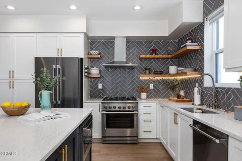 a kitchen with stainless steel appliances granite countertop a stove a refrigerator and a stove