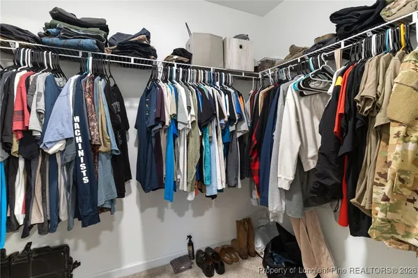 a view of walk in closet with clothes and shoes