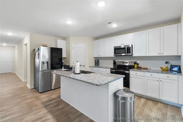 a kitchen with stainless steel appliances granite countertop a refrigerator sink and stove