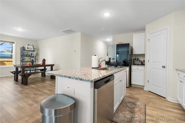 a kitchen with granite countertop cabinets a sink a counter space and stainless steel appliances