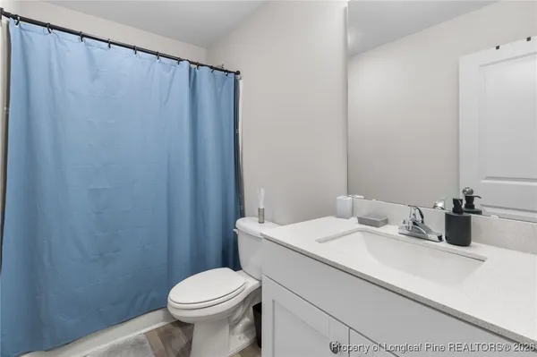 a bathroom with a sink a toilet and shower curtain