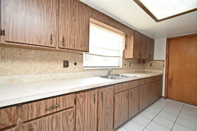 a kitchen with a sink window and cabinets