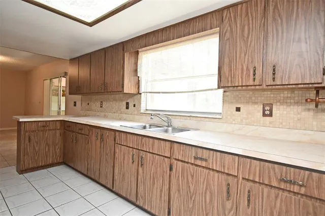 a kitchen with a sink window and cabinets