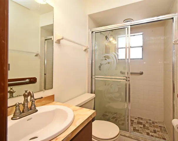 a bathroom with a sink toilet and shower