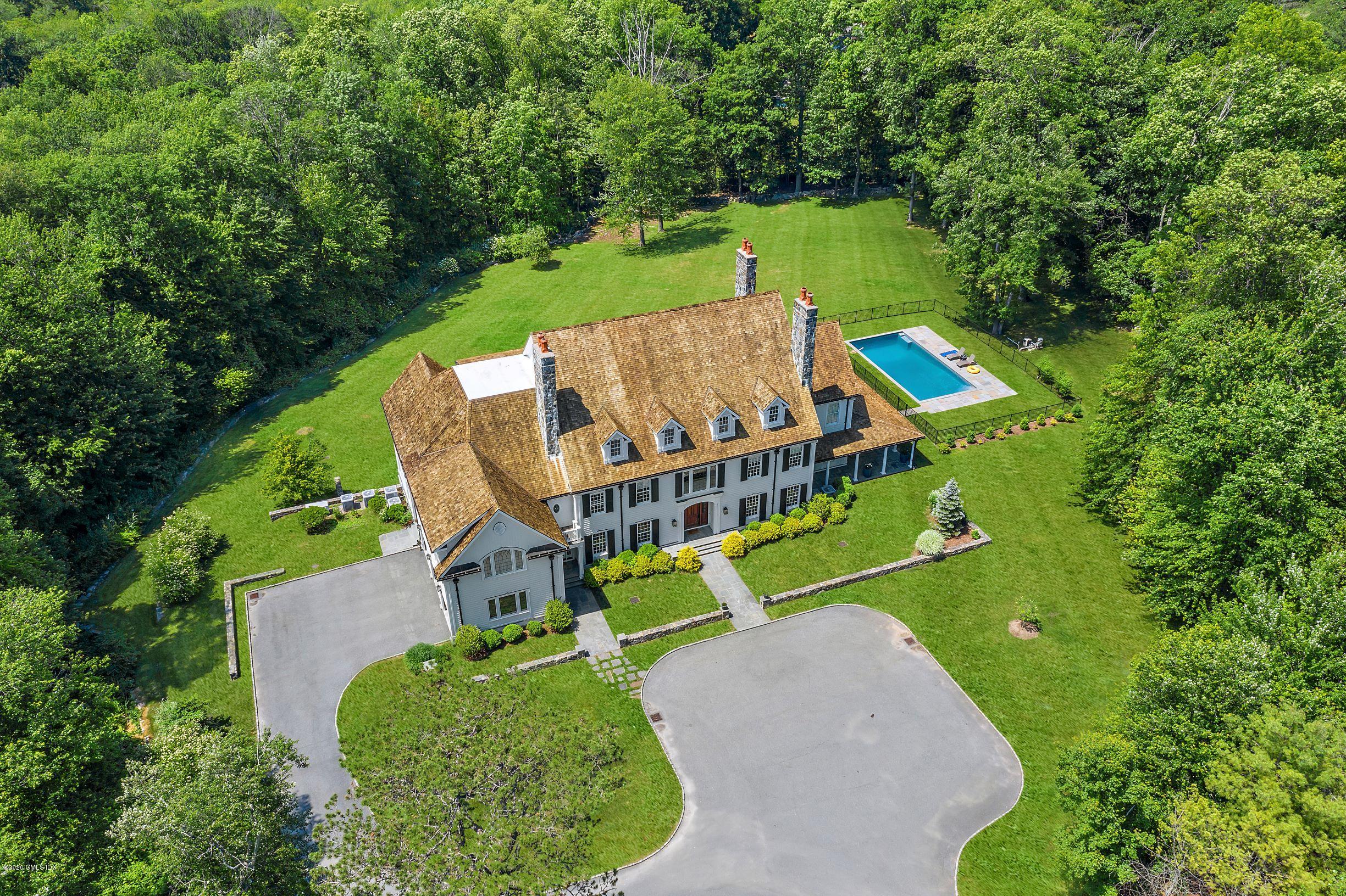 an aerial view of a house with a big yard and large trees