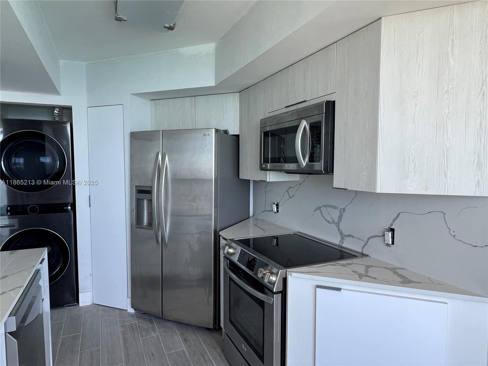 6301 Collins Avenue, Unit 3002 Miami Beach, FL 33141 - Photo 11 of 27 a kitchen with a sink and a refrigerator