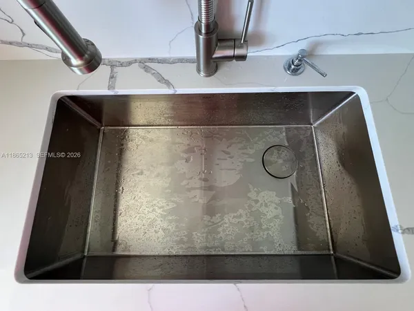 a spacious bathroom with a double vanity sink a mirror and a toilet