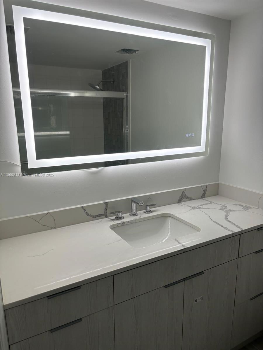 6301 Collins Avenue, Unit 3002 Miami Beach, FL 33141 - Photo 20 of 27 a bathroom with a sink and a mirror