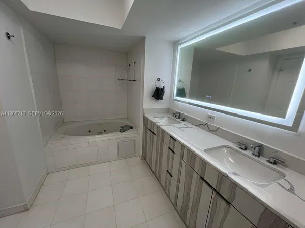 a view of an empty room with wooden floor and closet