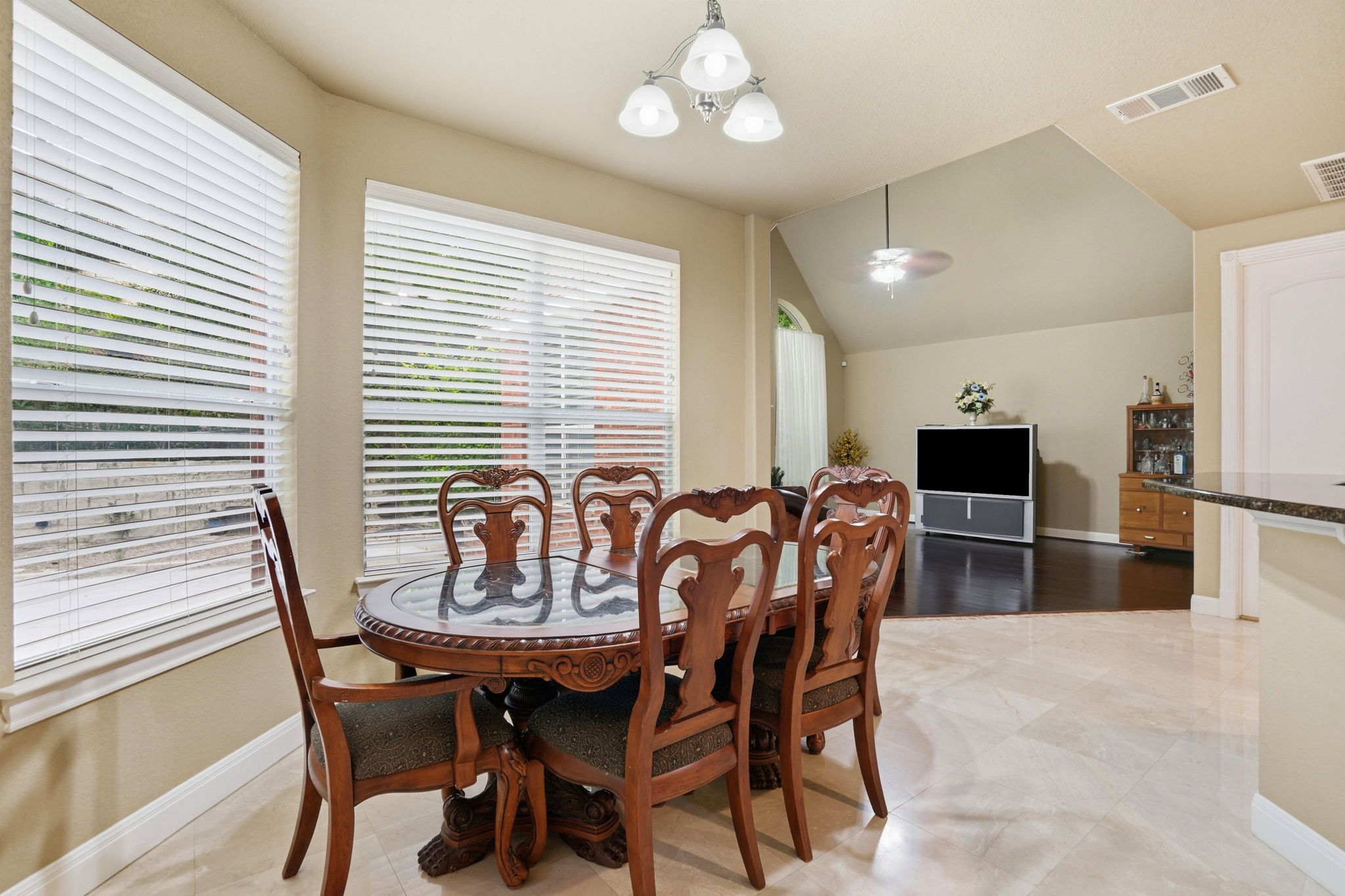 222 Vailco Lane Austin, TX 78738 - Photo 24 of 39 Dining area featuring light-toned tile flooring, multiple windows with blinds, and an overhead chandelier-style light fixture