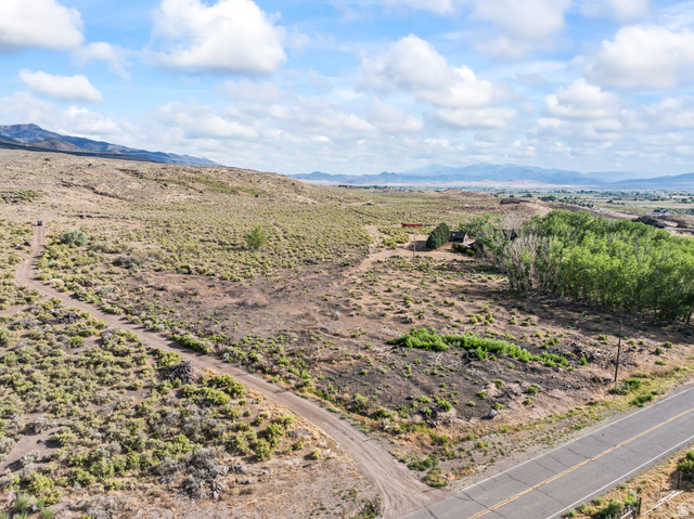 460 Omni Point Road Central Valley, UT 84754 - Photo 98 of 101 Expansive undeveloped land featuring natural vegetation, a paved road border, and a distant mountain range backdrop