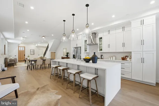 a large white kitchen with lots of counter space and windows
