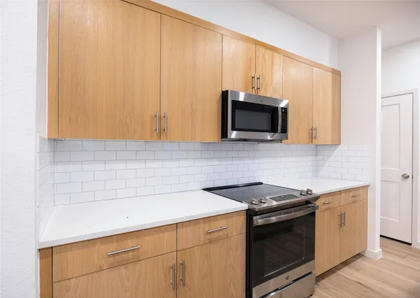 a kitchen with a sink a stove a microwave and a refrigerator
