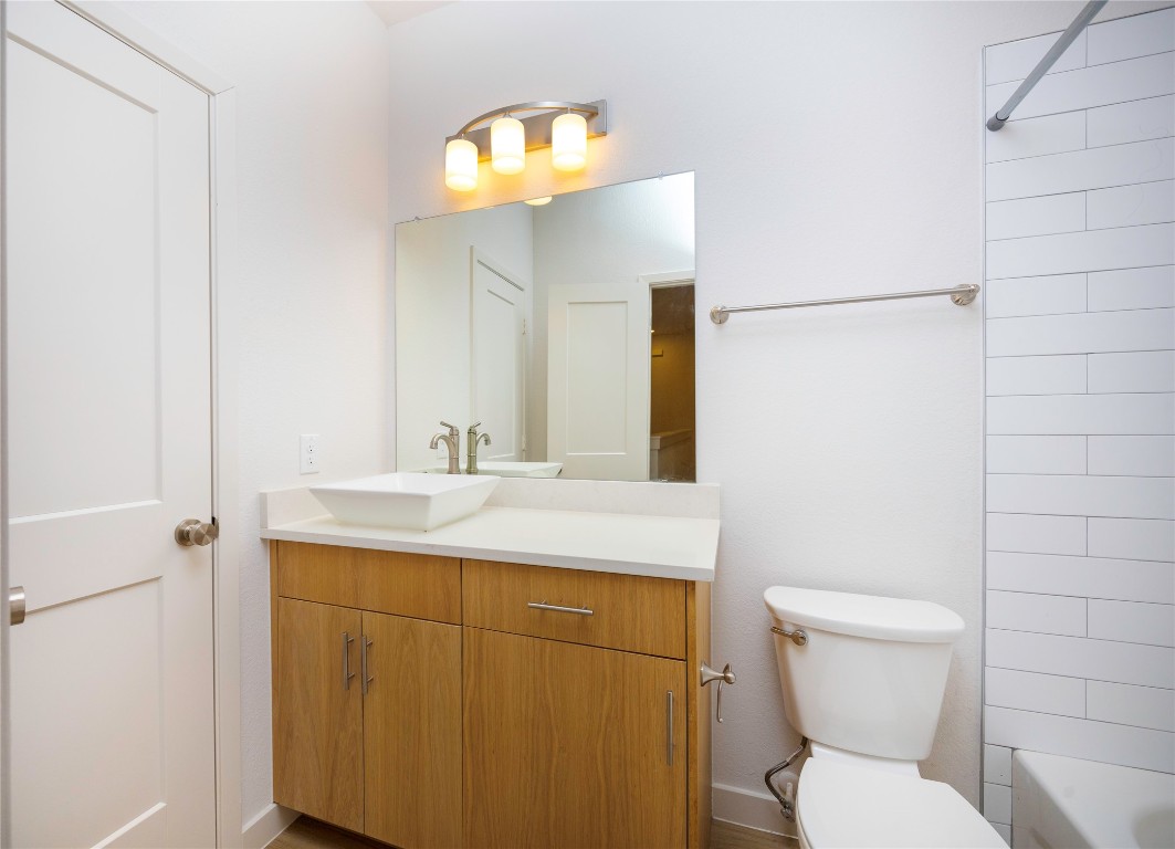 2517 Appian Way, Unit B Roman Forest, TX 77357 - Photo 31 of 37 a bathroom with a toilet sink vanity and mirror