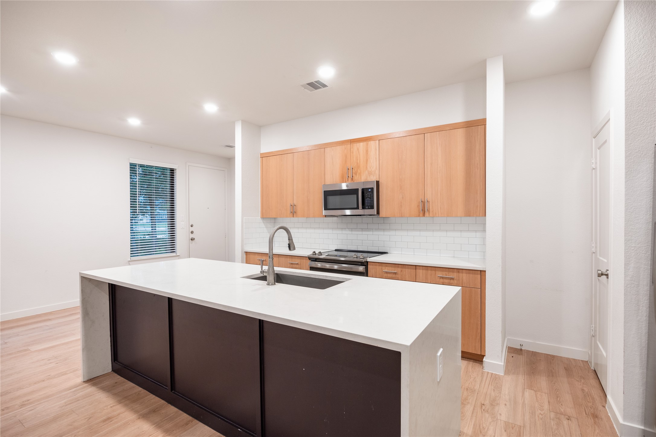 2517 Appian Way, Unit B Roman Forest, TX 77357 - Photo 7 of 31 a kitchen with a sink a stove a microwave and a refrigerator