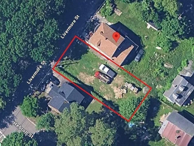 an aerial view of a red and white house with a yard and garden