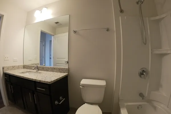 a bathroom with a sink toilet vanity and shower