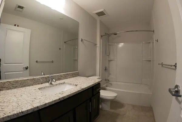 a bathroom with a granite countertop sink toilet and shower