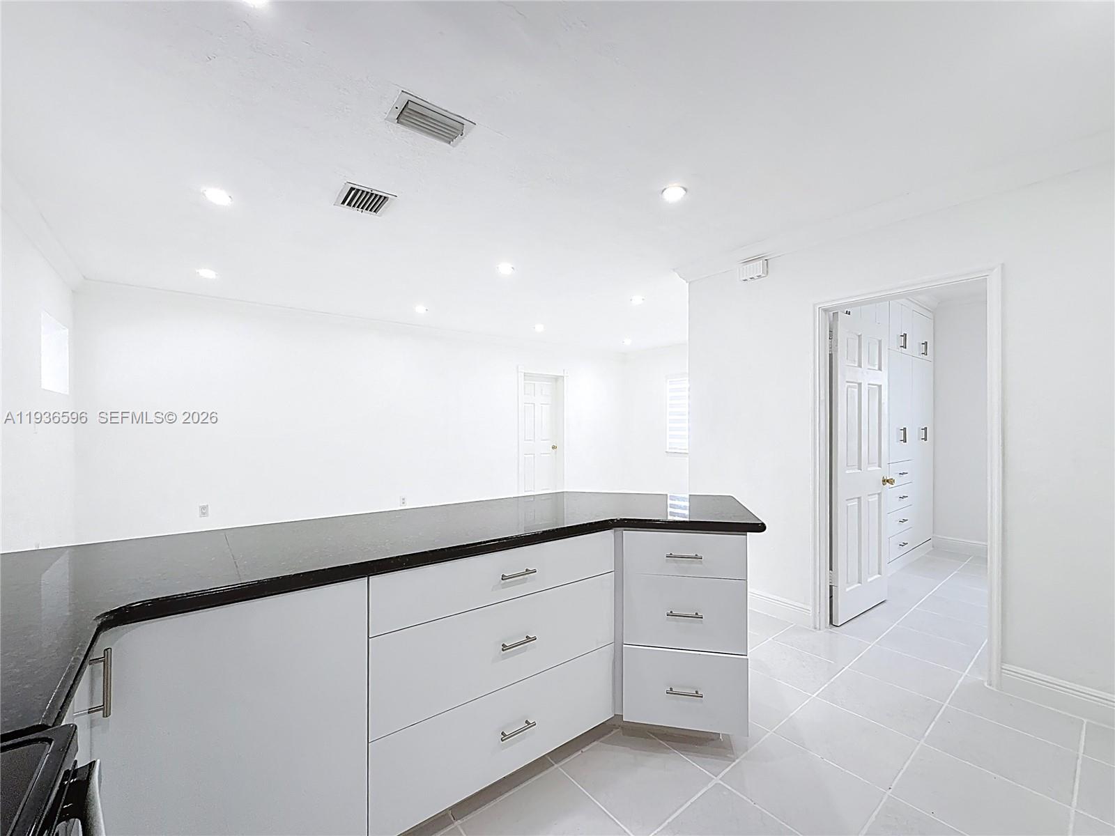 7410 Southwest 39th Street Miami, FL 33155 - Photo 17 of 47 a kitchen with granite countertop white cabinets and white appliances