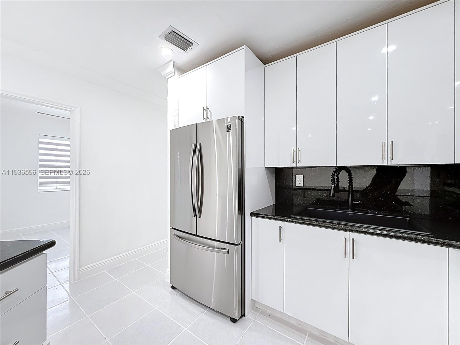 7410 Southwest 39th Street Miami, FL 33155 - Photo 18 of 47 a kitchen with stainless steel appliances a refrigerator a sink and cabinets