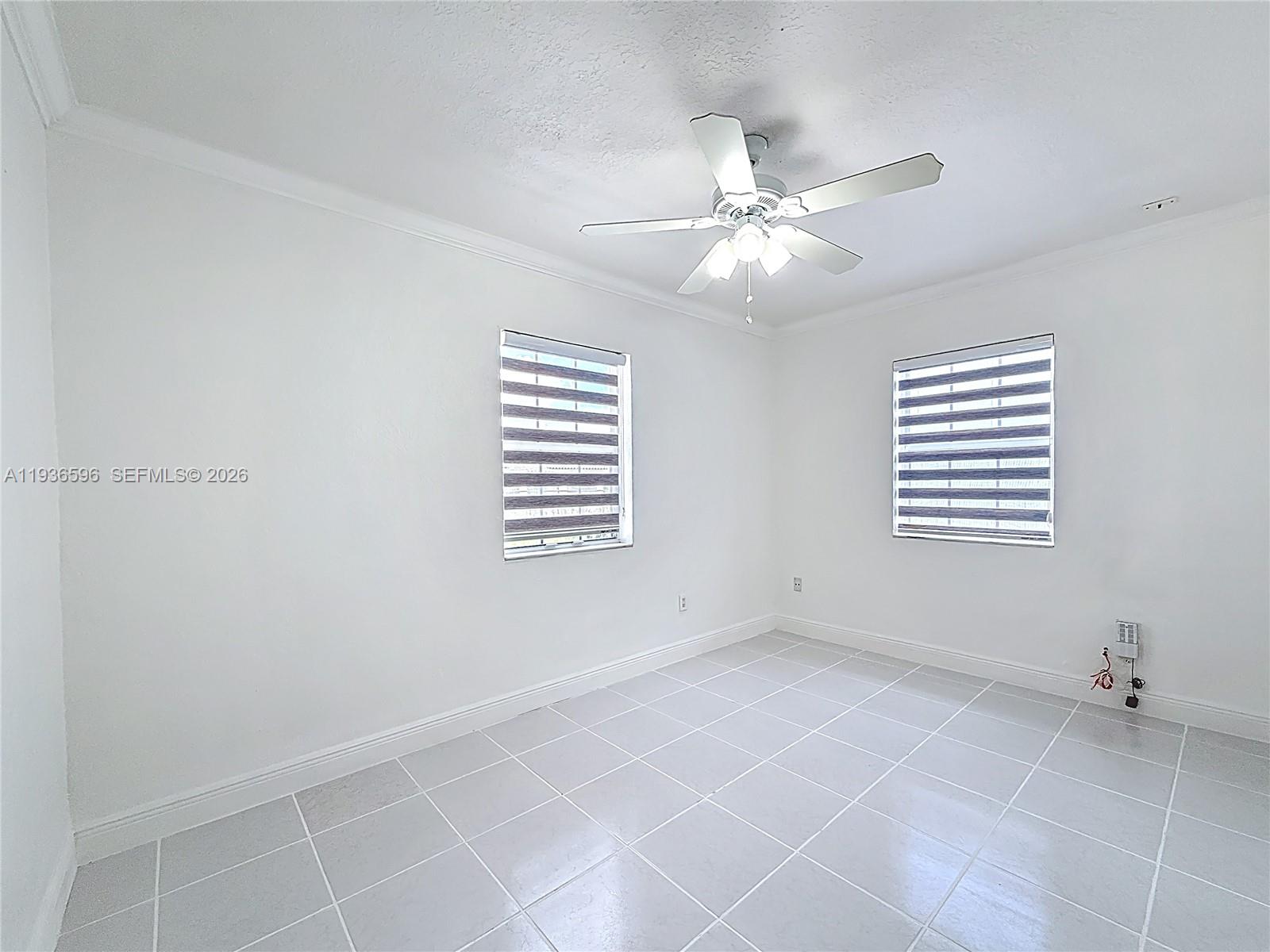 7410 Southwest 39th Street Miami, FL 33155 - Photo 21 of 47 a view of an empty room with a window and a ceiling fan