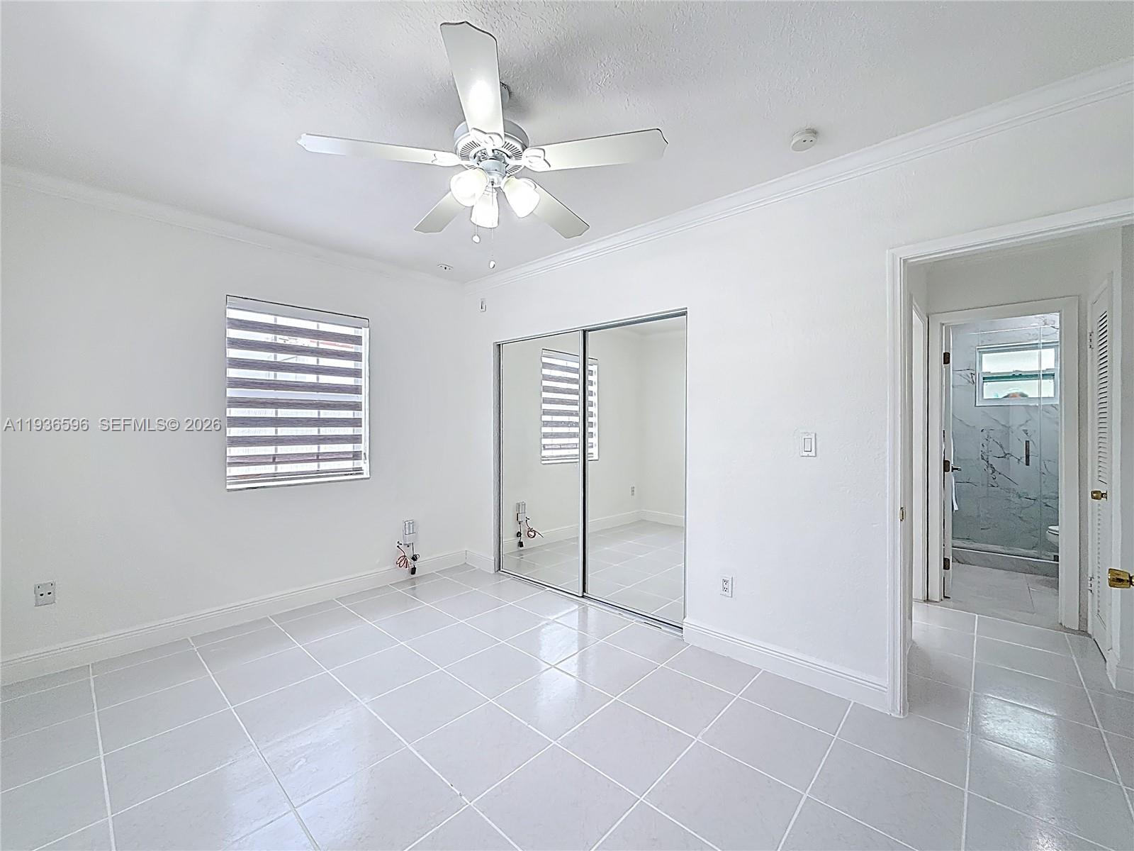 7410 Southwest 39th Street Miami, FL 33155 - Photo 23 of 47 a view of an empty room with window and chandelier fan