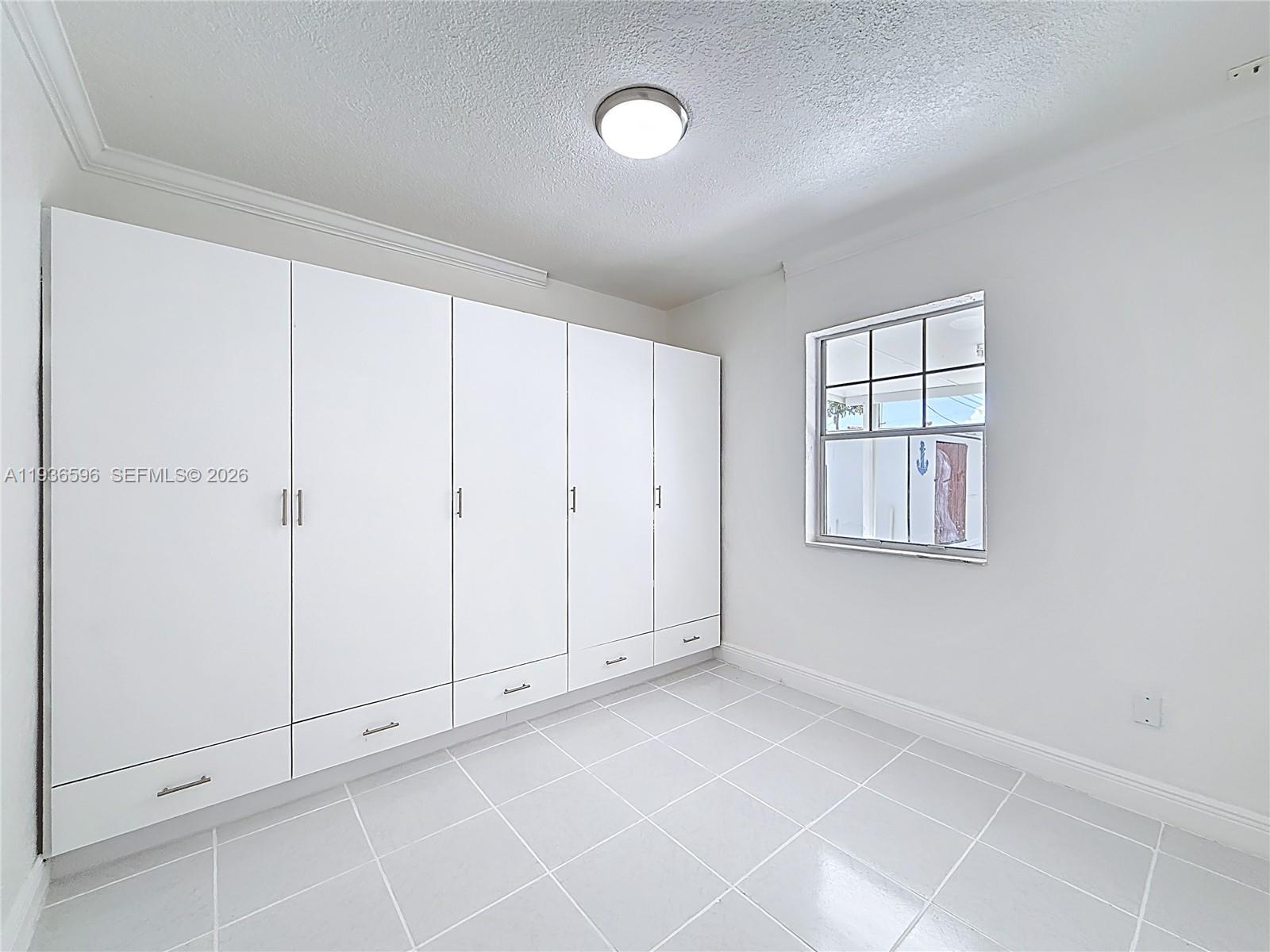 7410 Southwest 39th Street Miami, FL 33155 - Photo 26 of 47 a view of an empty room with window and cabinet