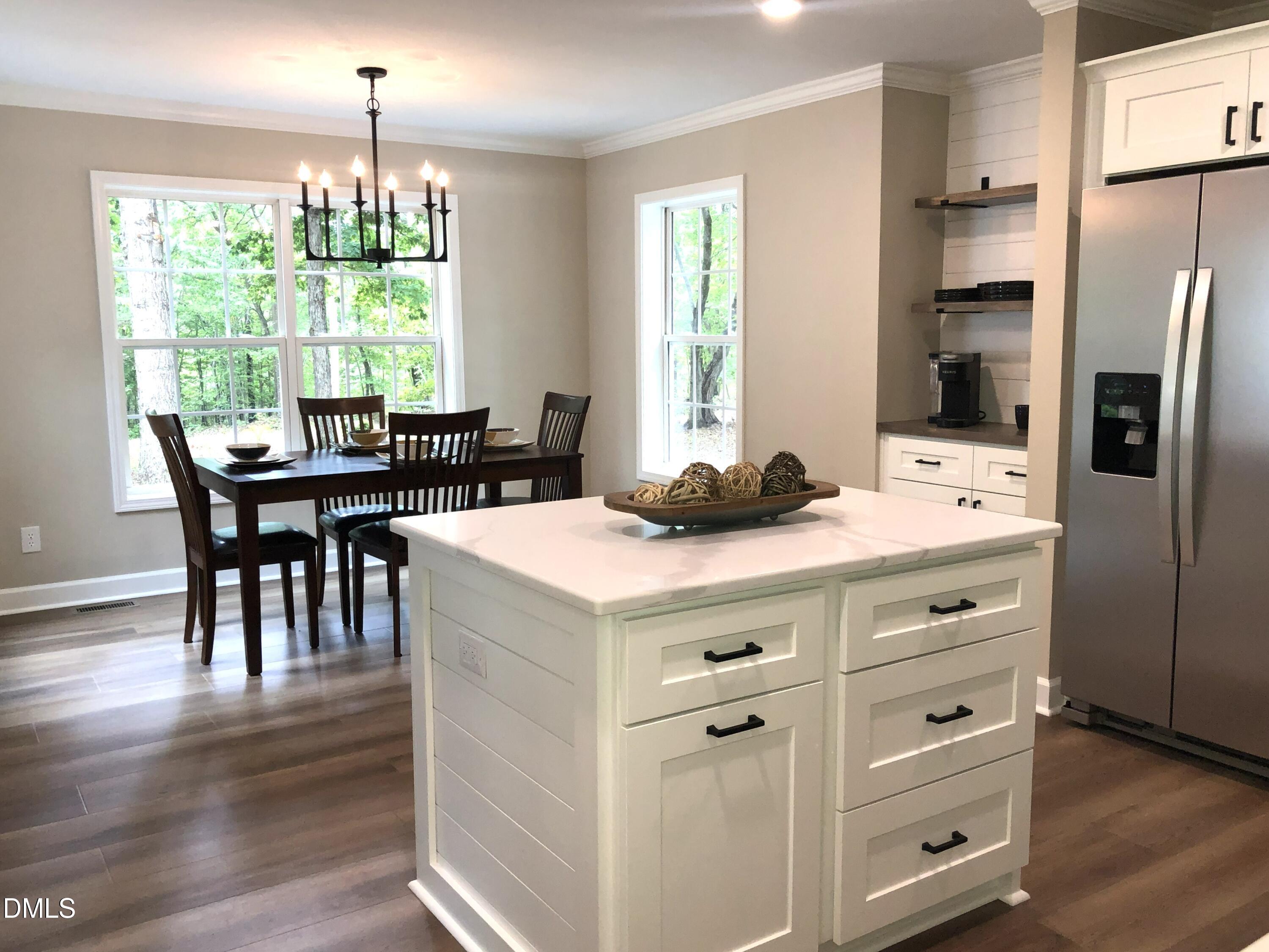 95 Smith Taylor Trail Roxboro, NC 27574 - Photo 17 of 47 a kitchen with a stove a refrigerator and a dining table with wooden floor