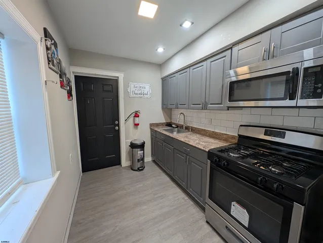 a kitchen with stainless steel appliances a stove a microwave and a refrigerator