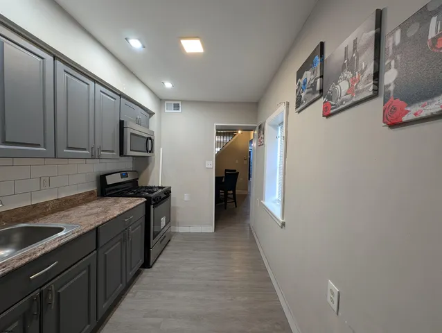 a kitchen with stainless steel appliances granite countertop a refrigerator and a sink